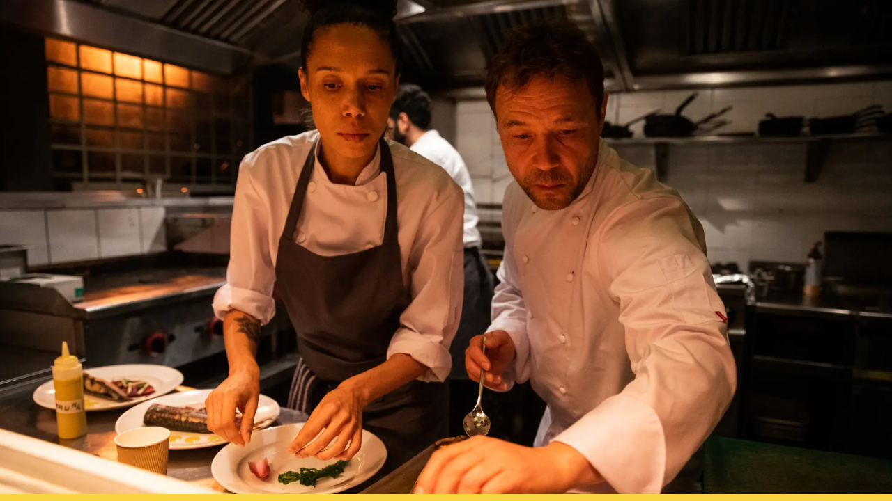 Chefs in a high-pressure kitchen focus intensely on plating during a tense dinner rush