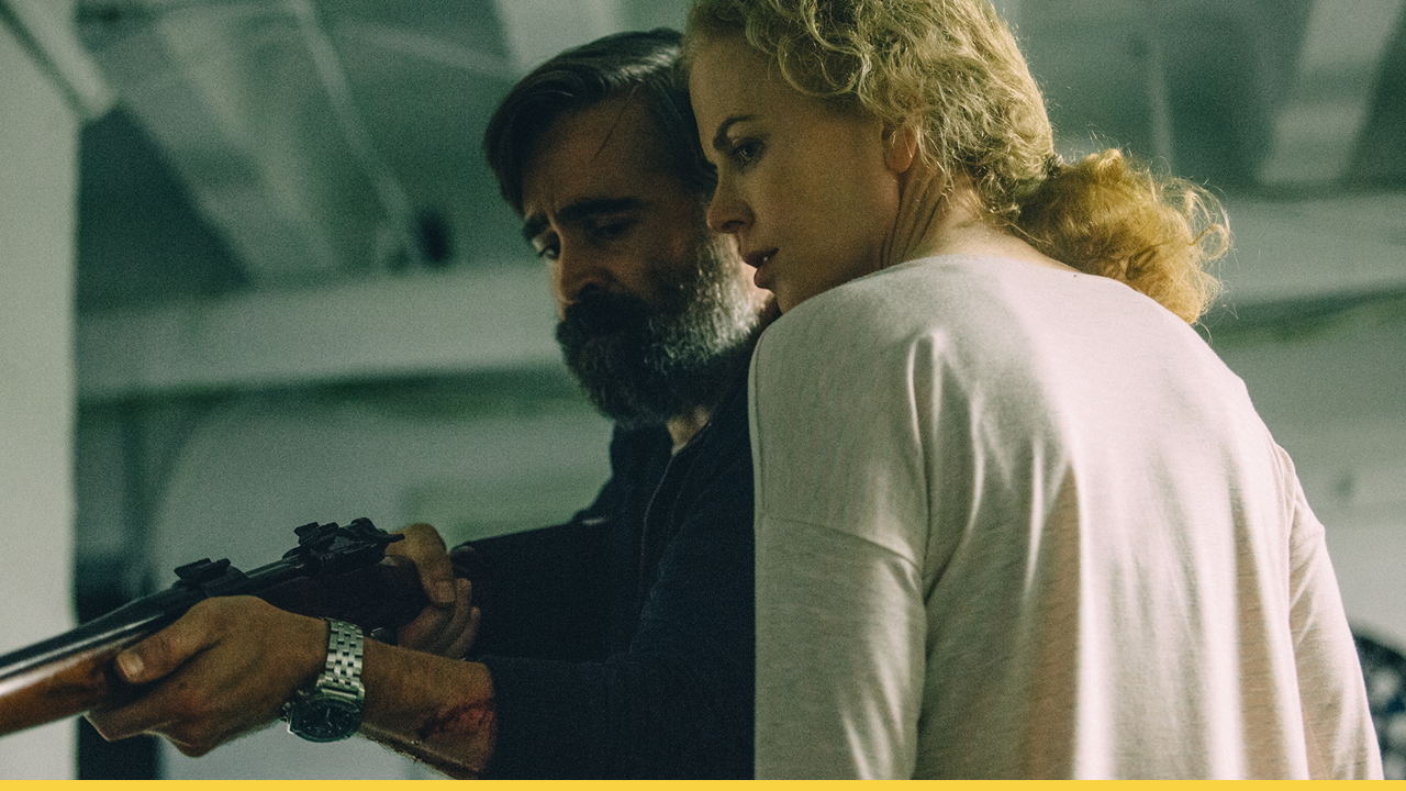 Two characters from The Killing of a Sacred Deer holding a rifle together